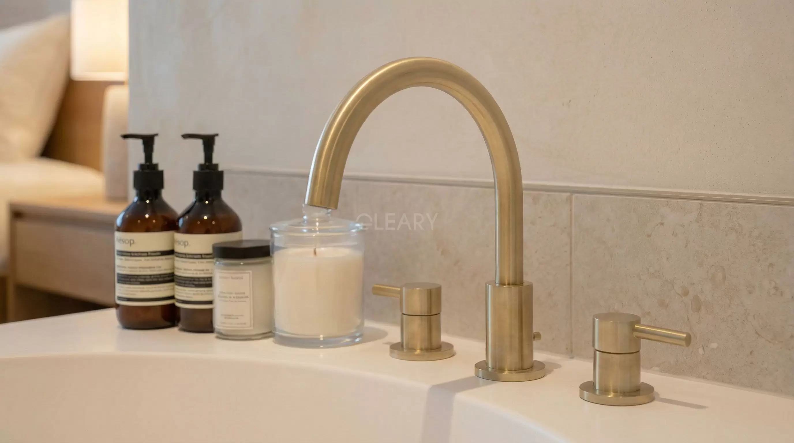 Solid Surface Bathtub Hardware Detail Detail shot of a matte white solid surface bathtub with premium brushed brass floor-mounted tub filler in a boutique hotel